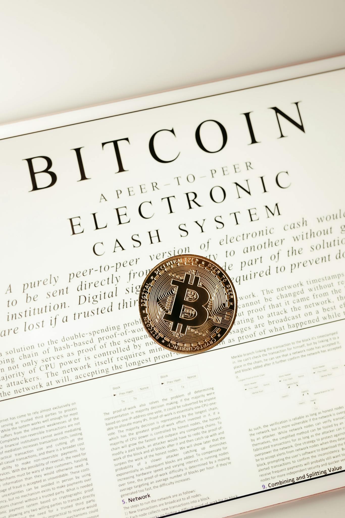 Close-up of a Bitcoin coin on the cryptocurrency's white paper showcasing digital cash concept.